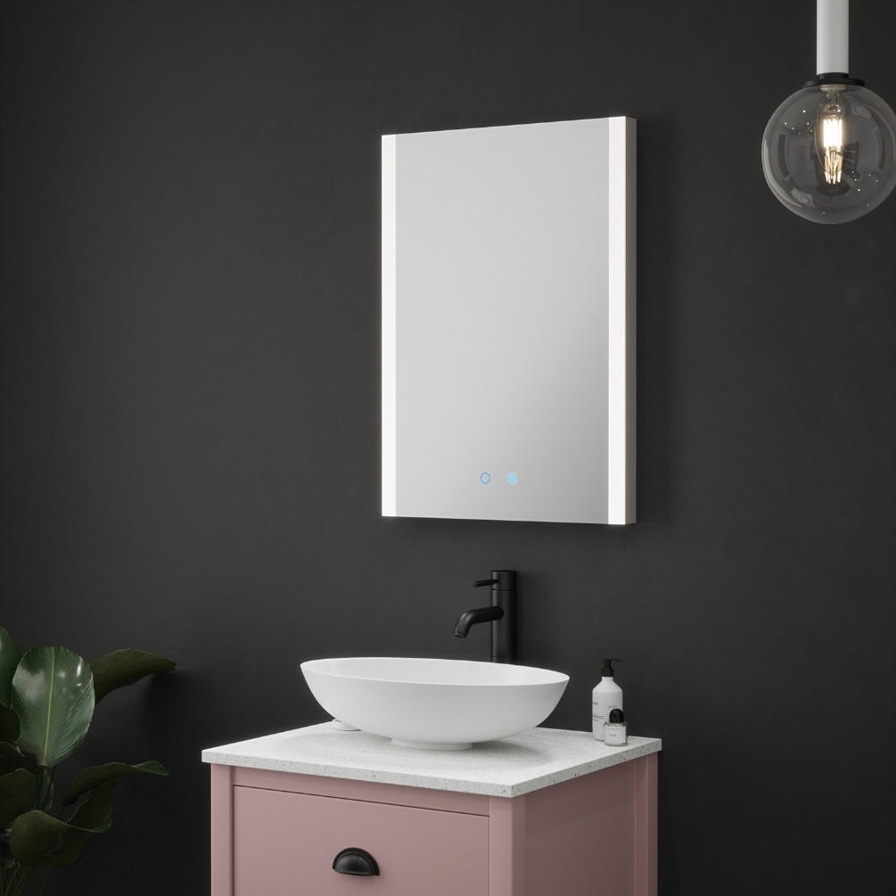 Product Lifestyle image of the Polar Colour Changing LED Mirror mounted above a pink vanity unit with countertop basin
